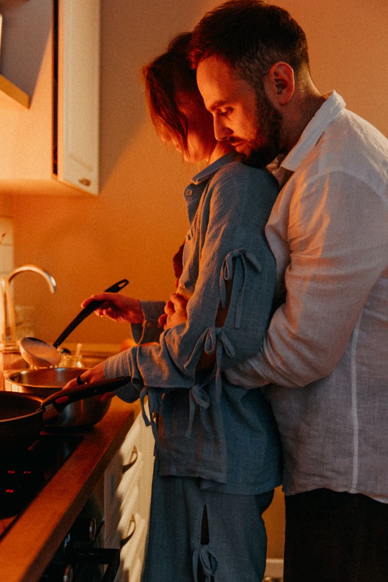 Intimate kitchen scene with couple standing close together at counter.