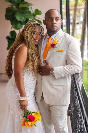 A series of wedding photos showing a couple in a beige suit and white dress posing outdoors near tropical greenery.
