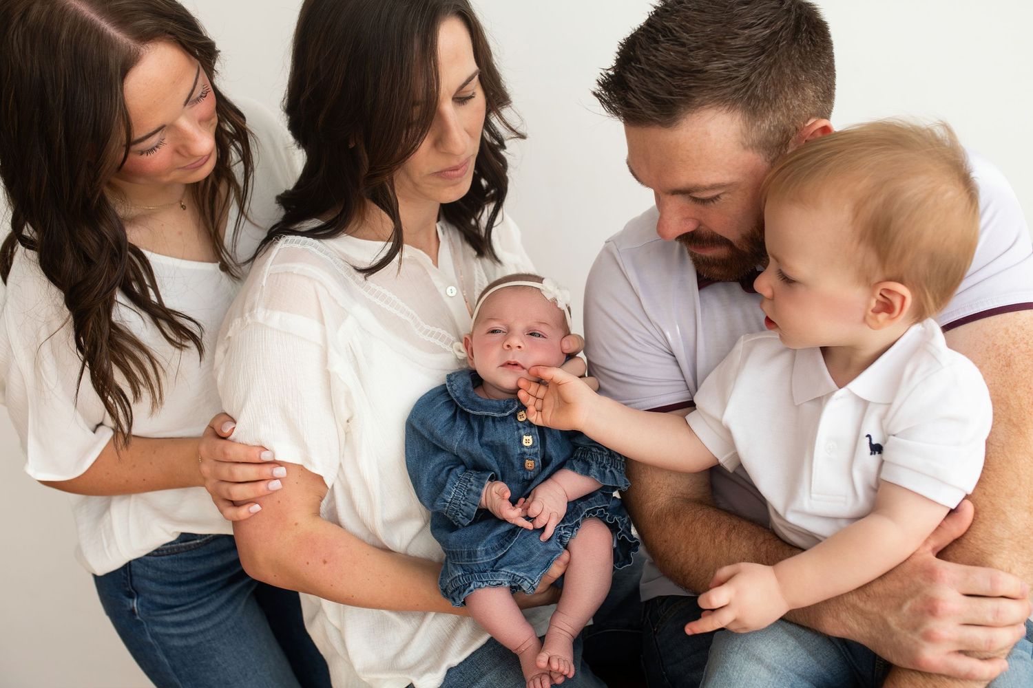 A collection of candid family moments showing parents and children interacting and playing together in a white studio setting.