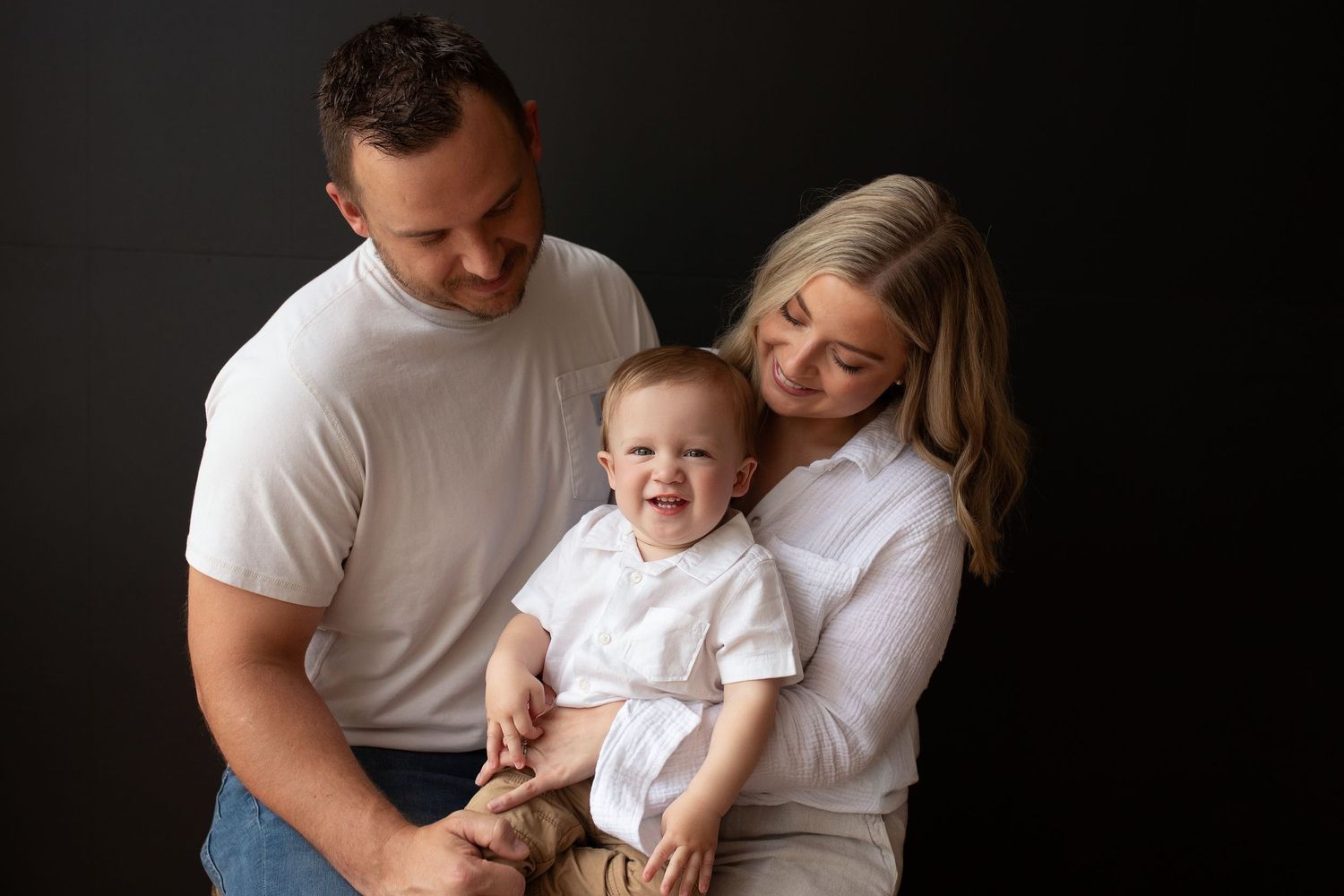 A series of intimate family photos showing tender moments between parents and children against a dark background.