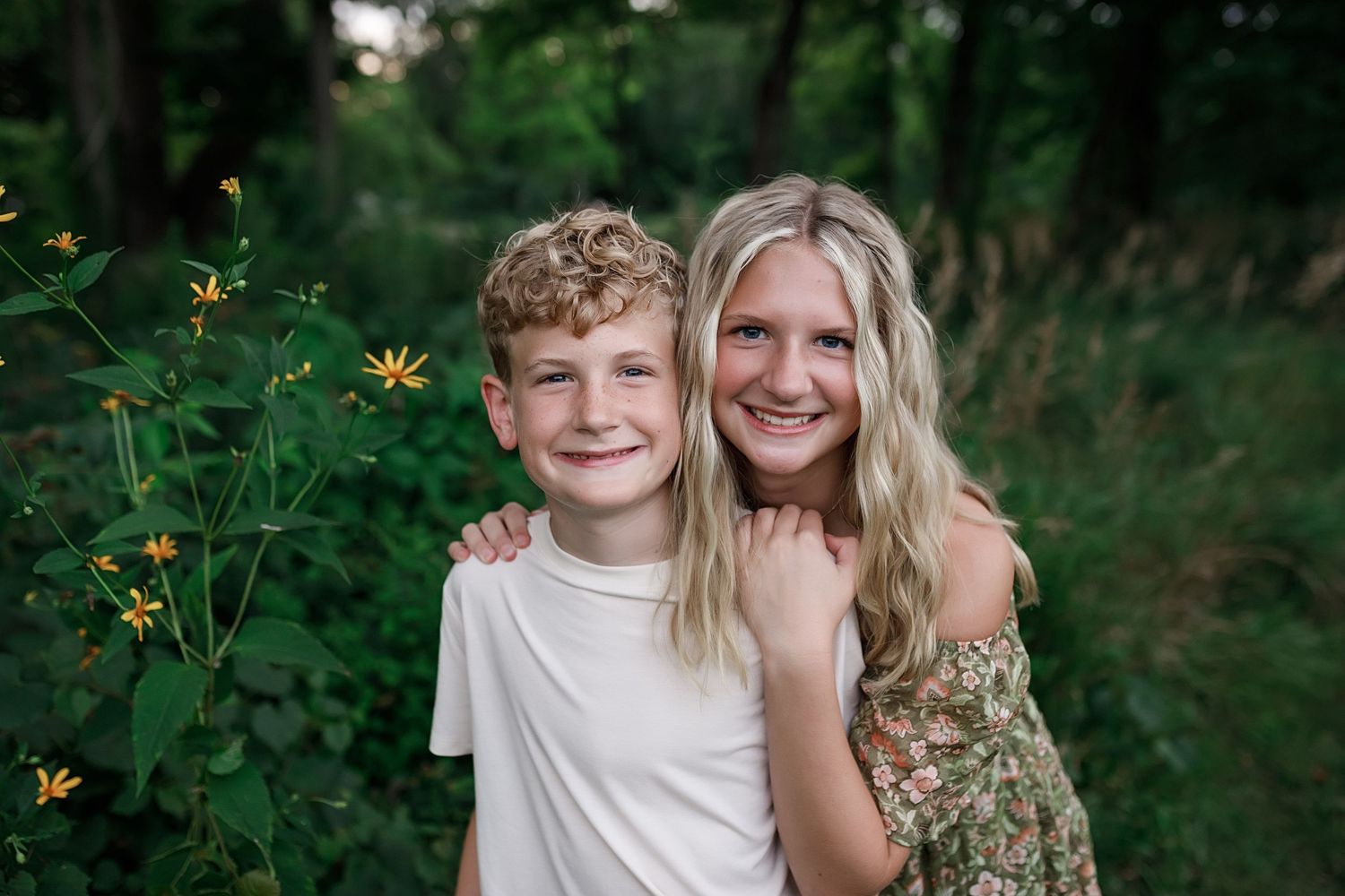 A mother and child share sweet moments together in an outdoor photo session among lush green foliage.