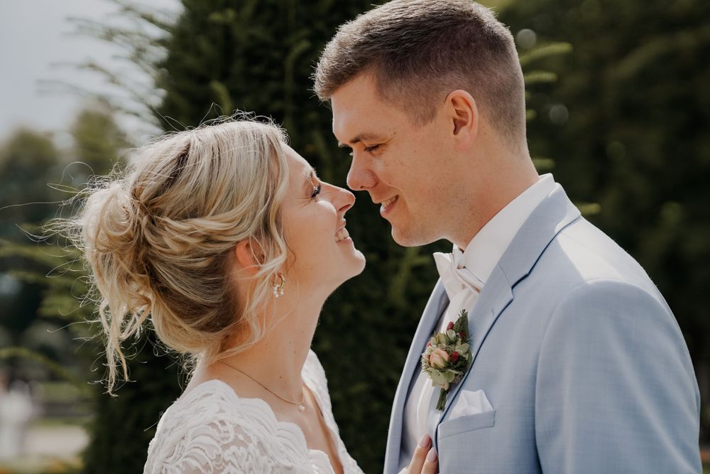 A romantic moment between newlyweds in a garden setting.