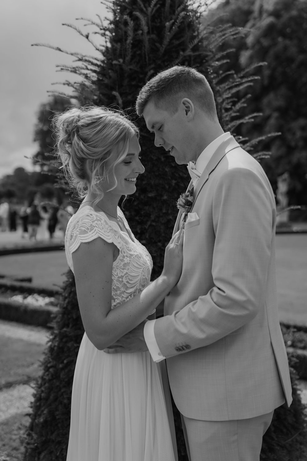 An intimate black and white portrait of a couple in wedding attire.