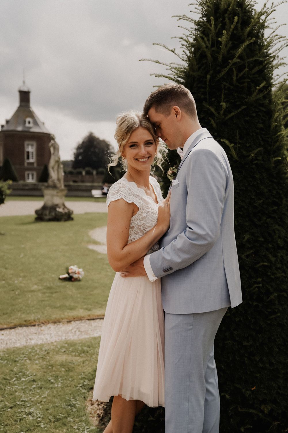 A romantic wedding portrait with a historic building in the background.