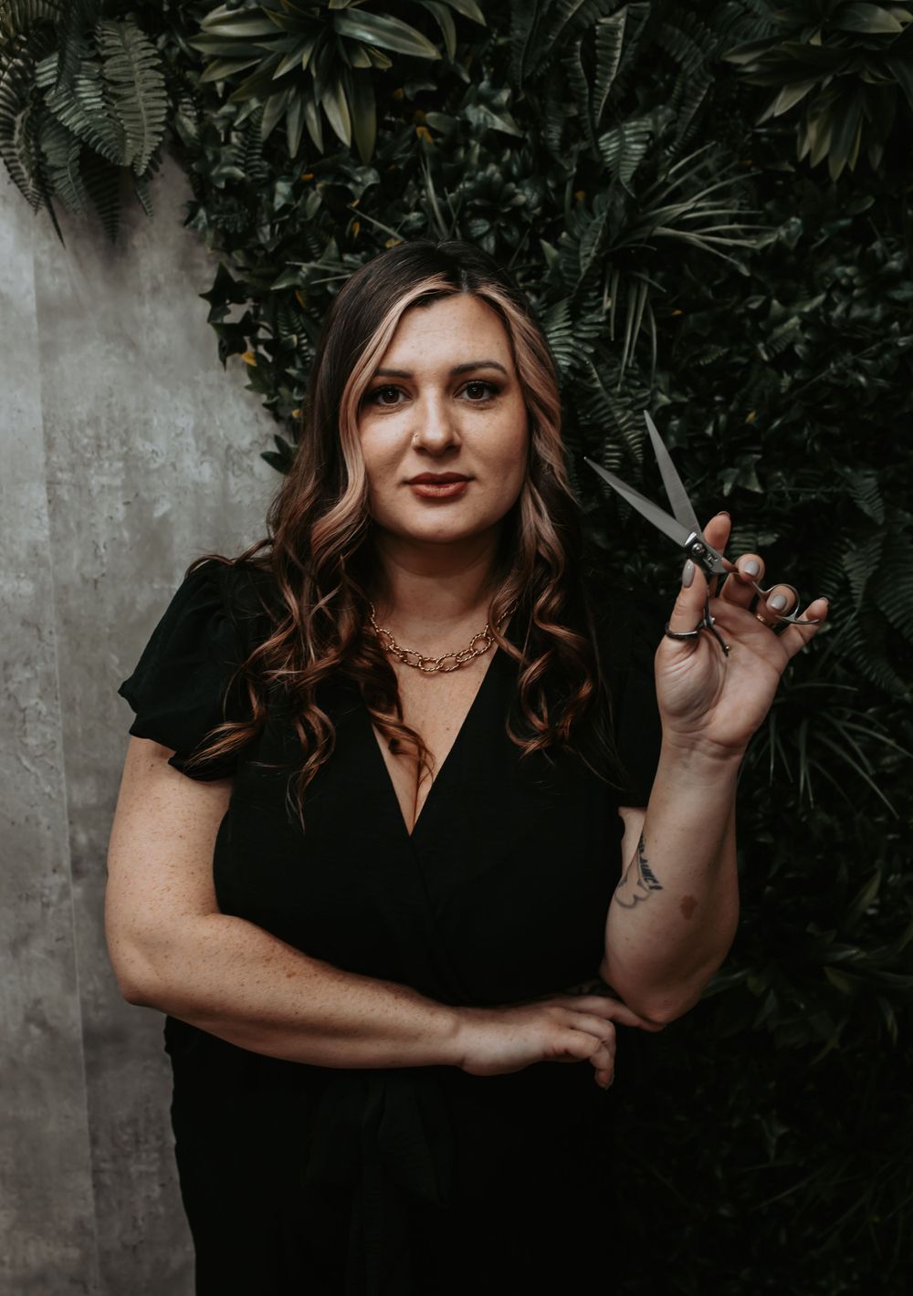 A stylish portrait session with dark foliage background and moody lighting.