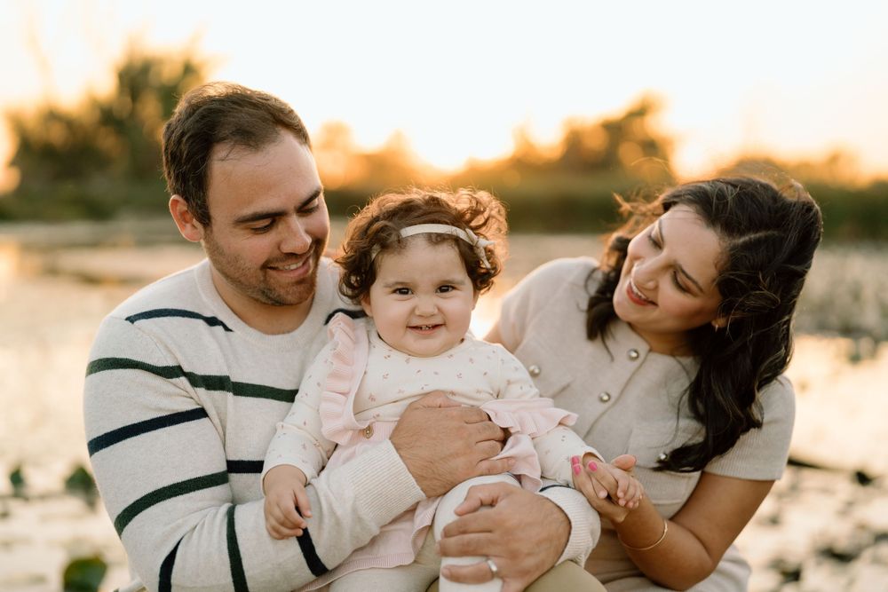 A family shares a tender moment together during golden hour at a beach location.