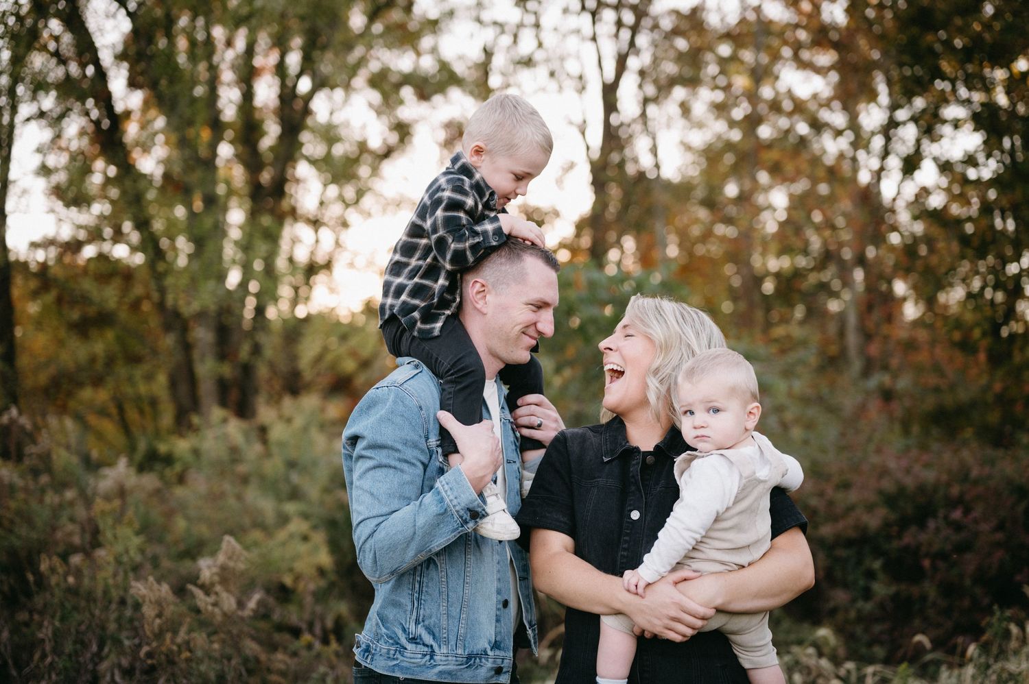Family of four enjoying outdoor autumn photo session together.