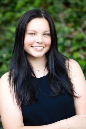 Portrait against lush green foliage background in natural lighting.