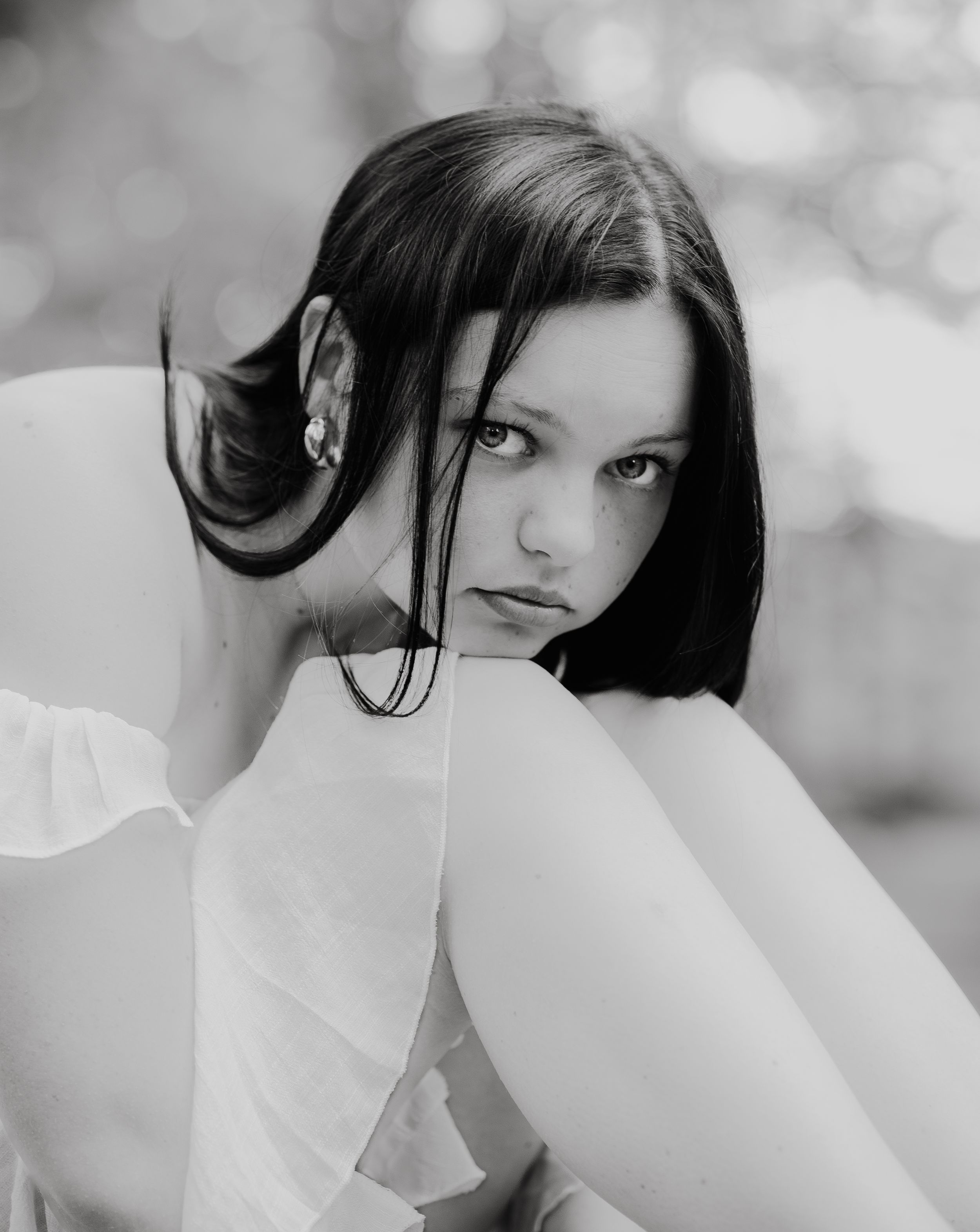 Artistic black and white portrait showcasing elegant pose and flowing fabric.