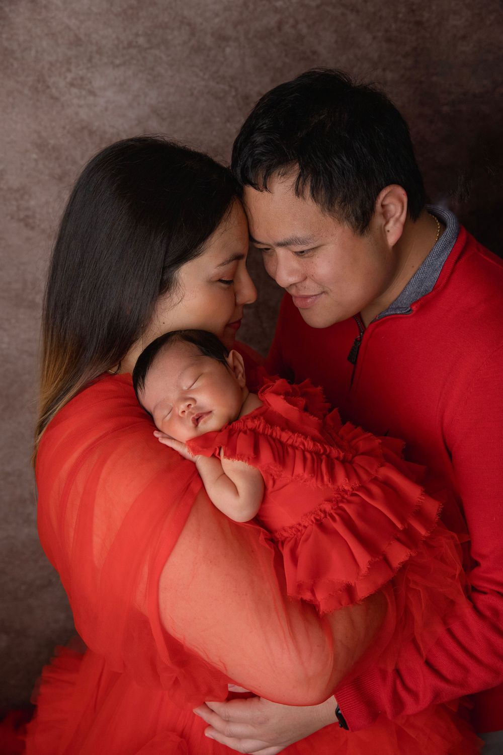 New parents holding newborn during studio newborn photography session in Central Florida.