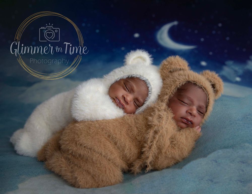 Twin newborns in bear and bunny outfits during themed newborn photography session.