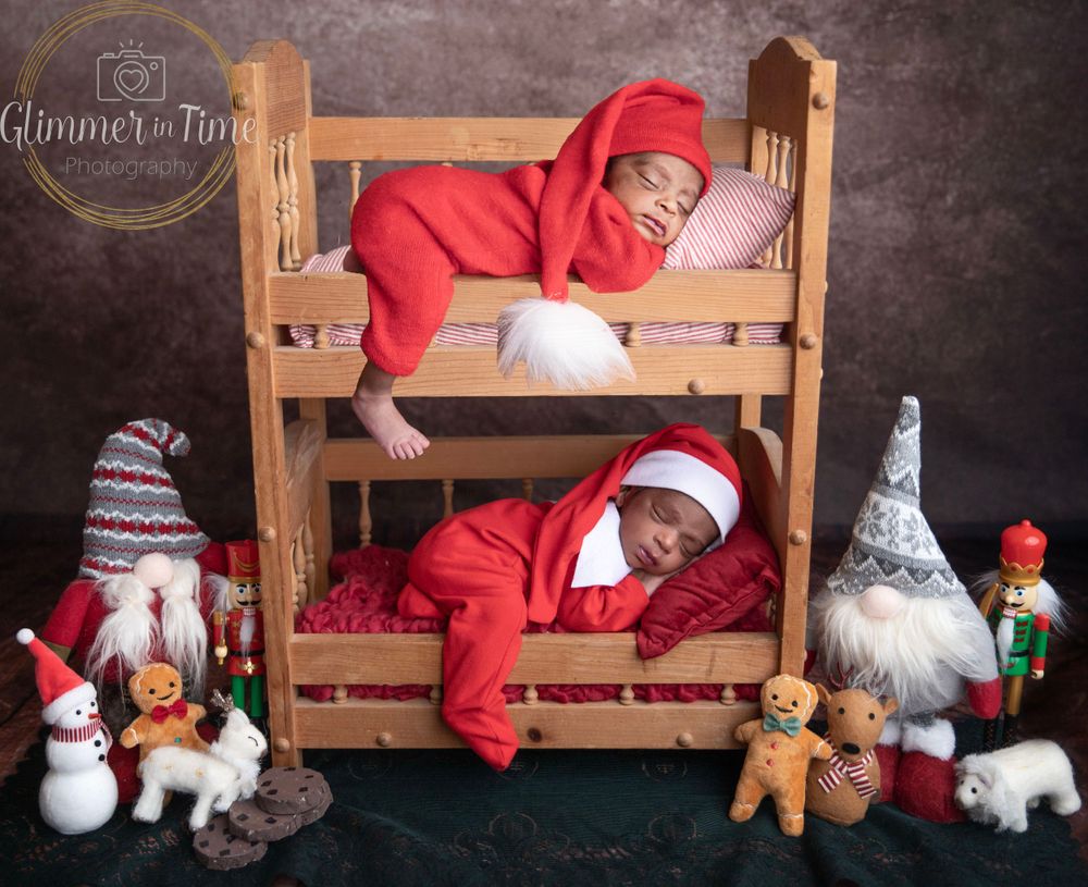 Twin newborns in Christmas setup during holiday newborn photography session in Central Florida.