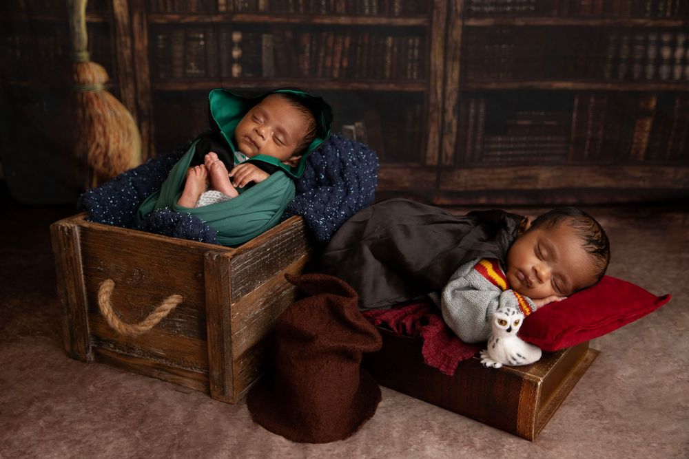 Twins newborn in Harry Potter inspired themed setup during creative newborn photography session in Central Florida.