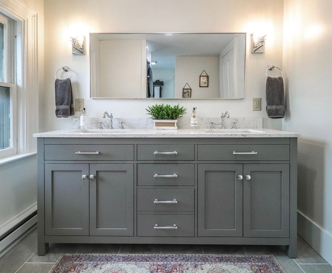 Gray double vanity bathroom with marble countertop, large mirror, and chrome fixtures.