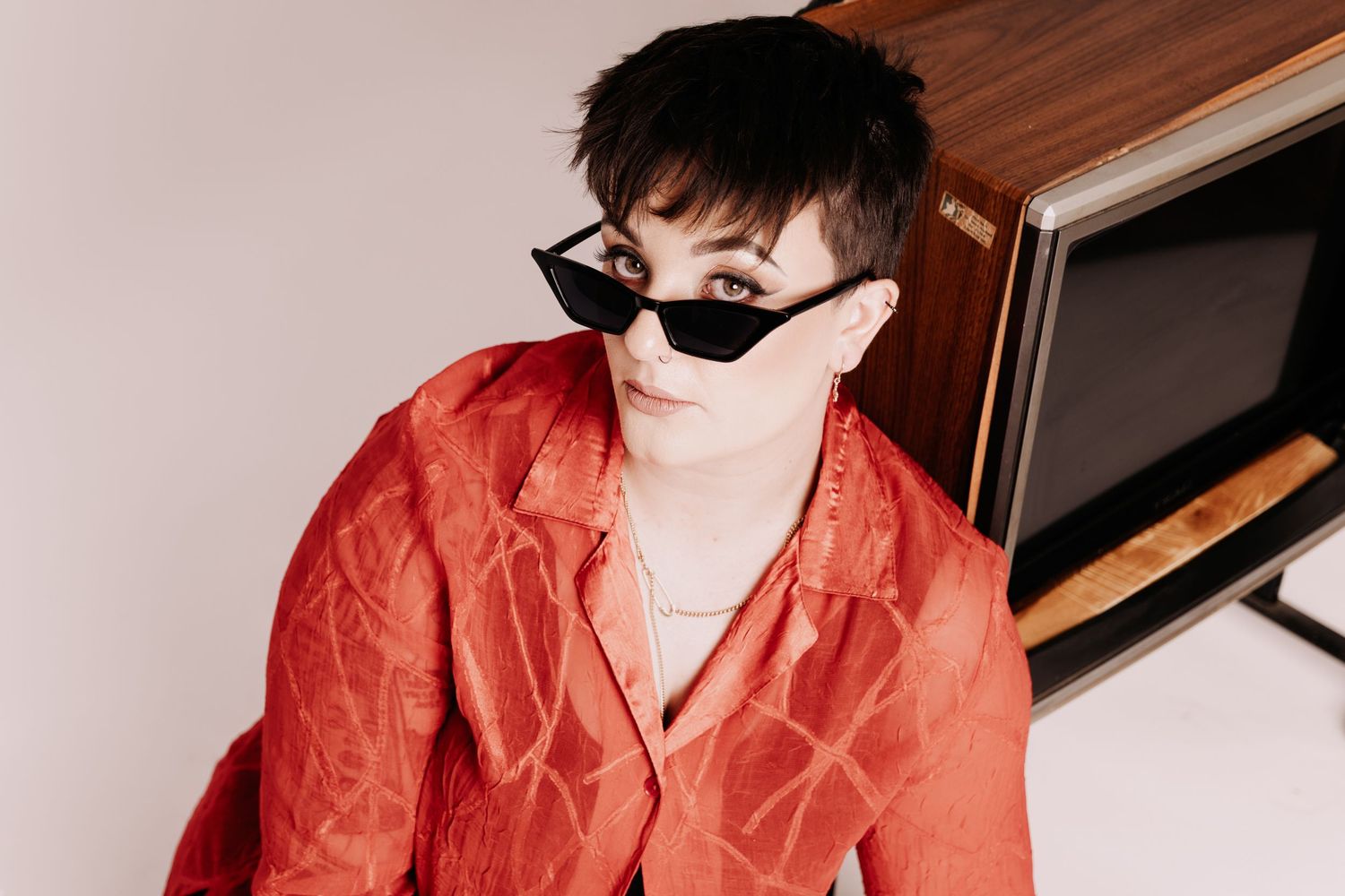A series of expressive portraits in red clothing against a light background.