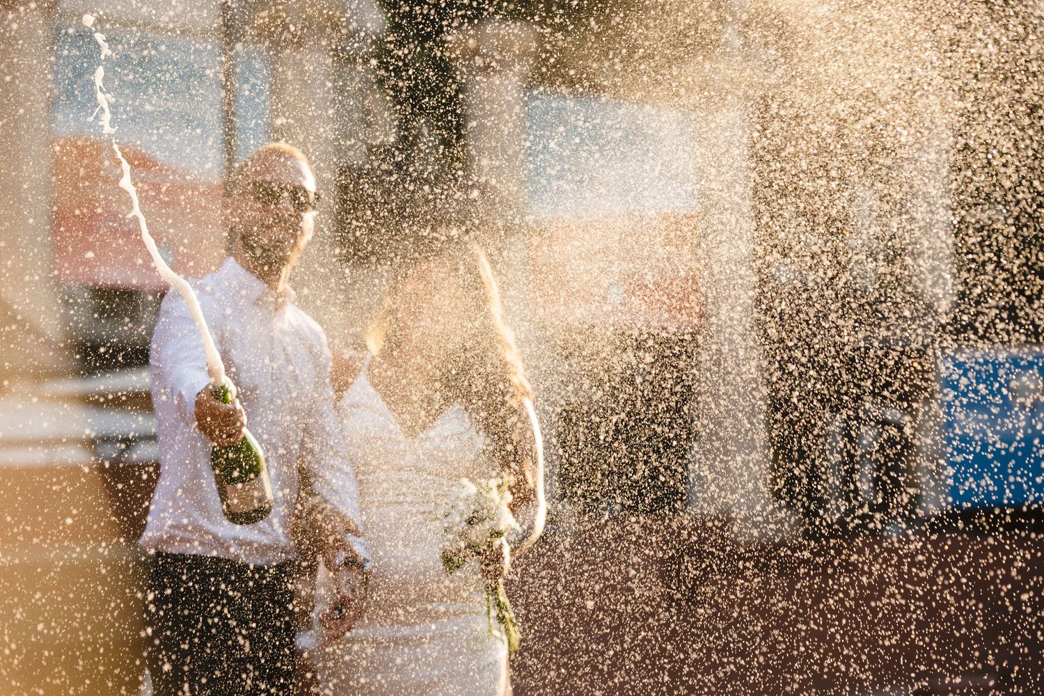 Celebratory champagne spray moment captured in backlit setting.