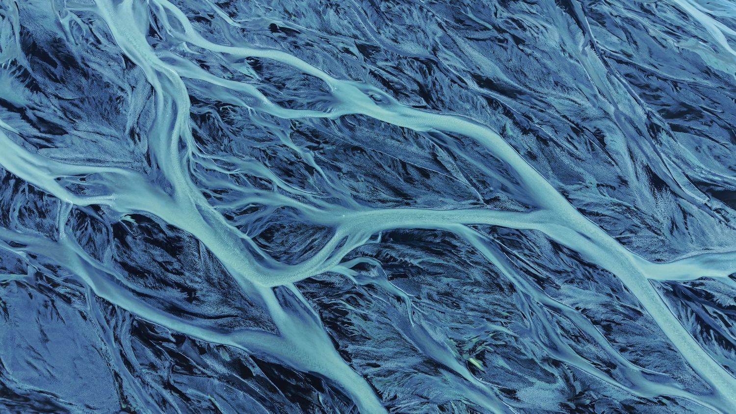 A blue supplement or vitamin bottle sits on a dark textured surface in moody lighting.