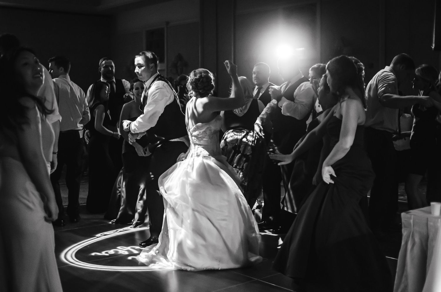 Bride and groom share an intimate first dance surrounded by guests at their elegant wedding reception.