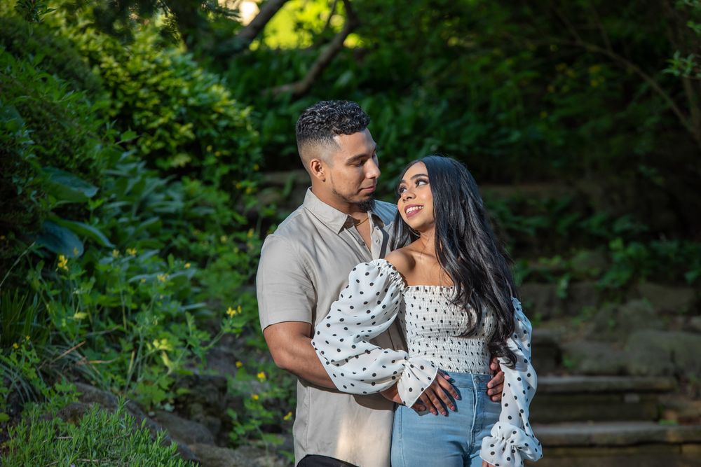 Close-up of a couple embracing in a lush green garden setting.