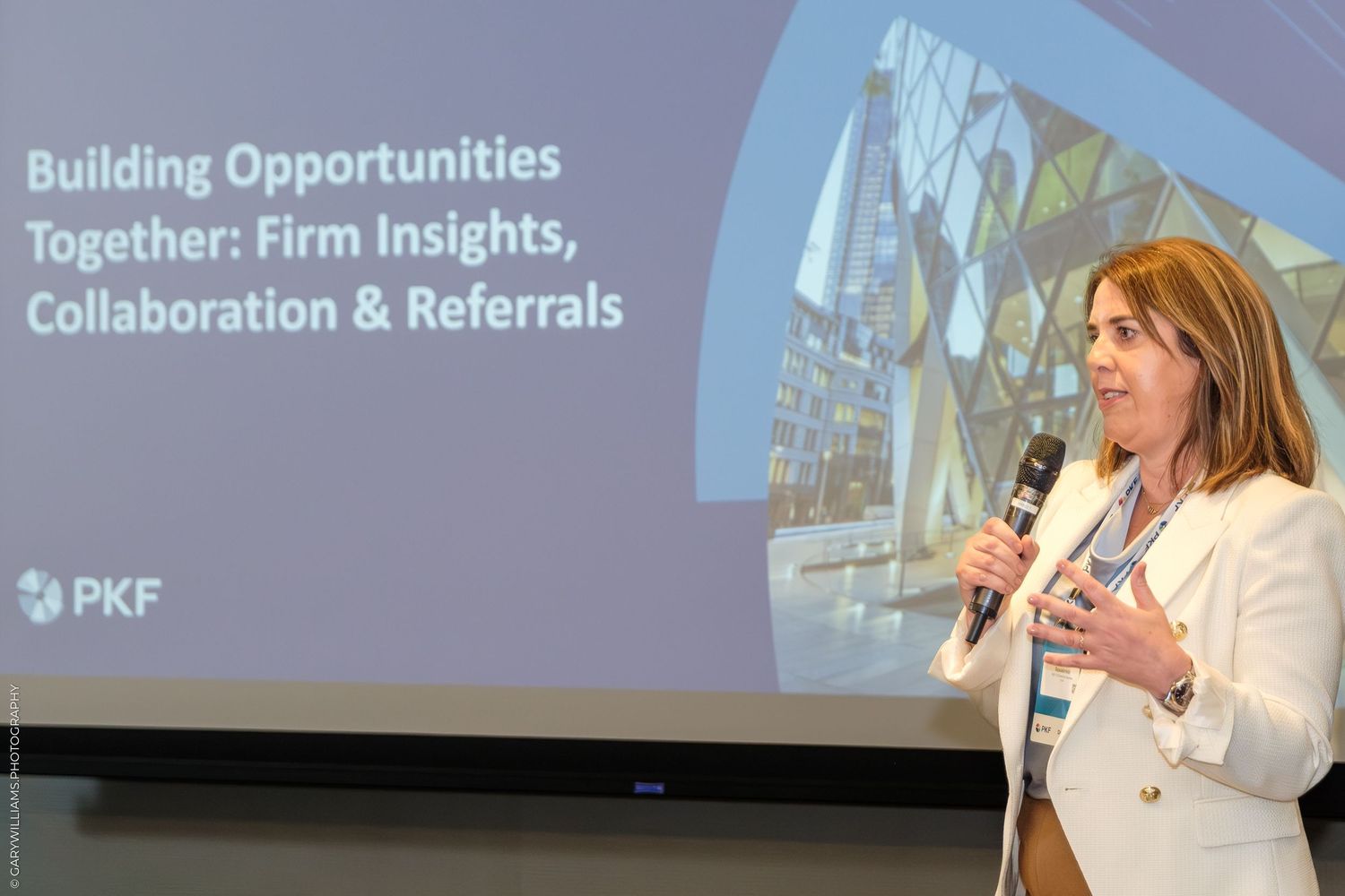 A woman presents at a PKF conference on Building Opportunities Together: Firm Insights, Collaboration & Referrals.