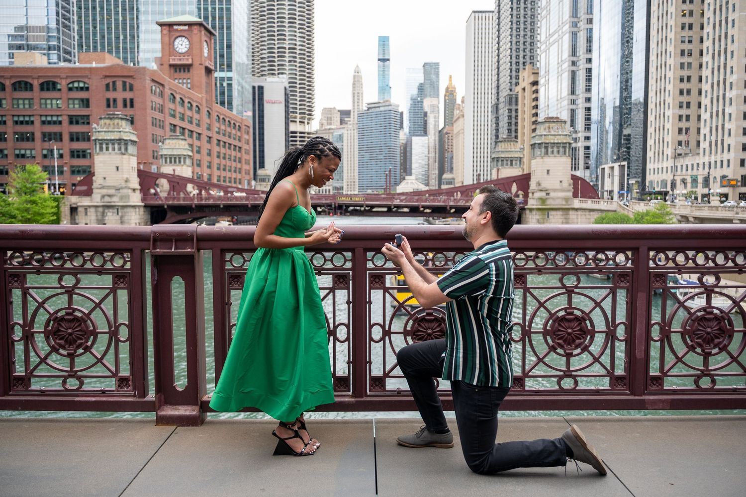 Man proposing on one knee to woman under stone arches in Central Park, NYC.
