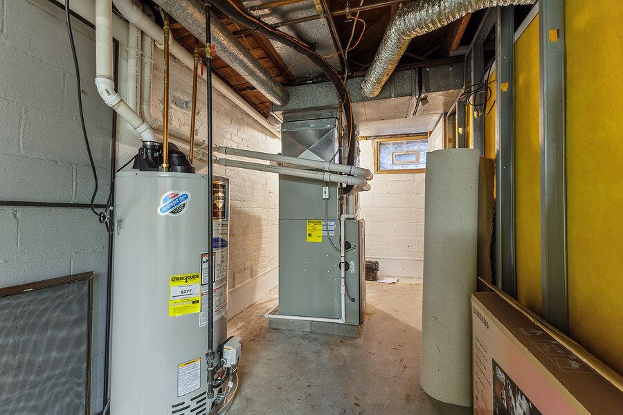 Basement utility room with water heater, HVAC system, and ductwork in a residential home.