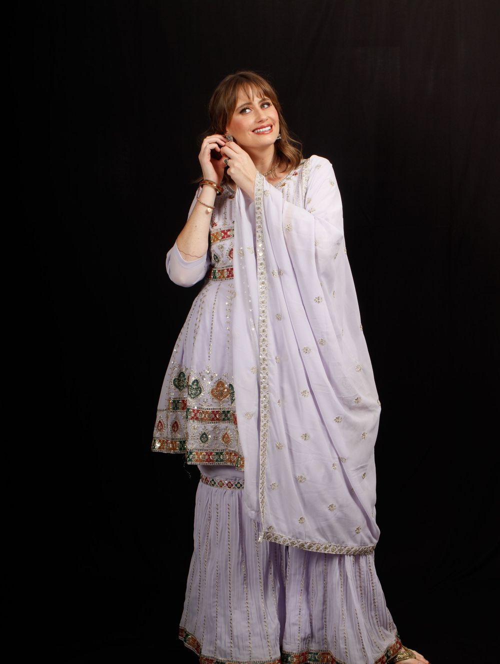 Fashion portrait of a woman in a traditional white outfit against a black background, photographed by Kai Shoots in Greater Noida, Delhi-NCR