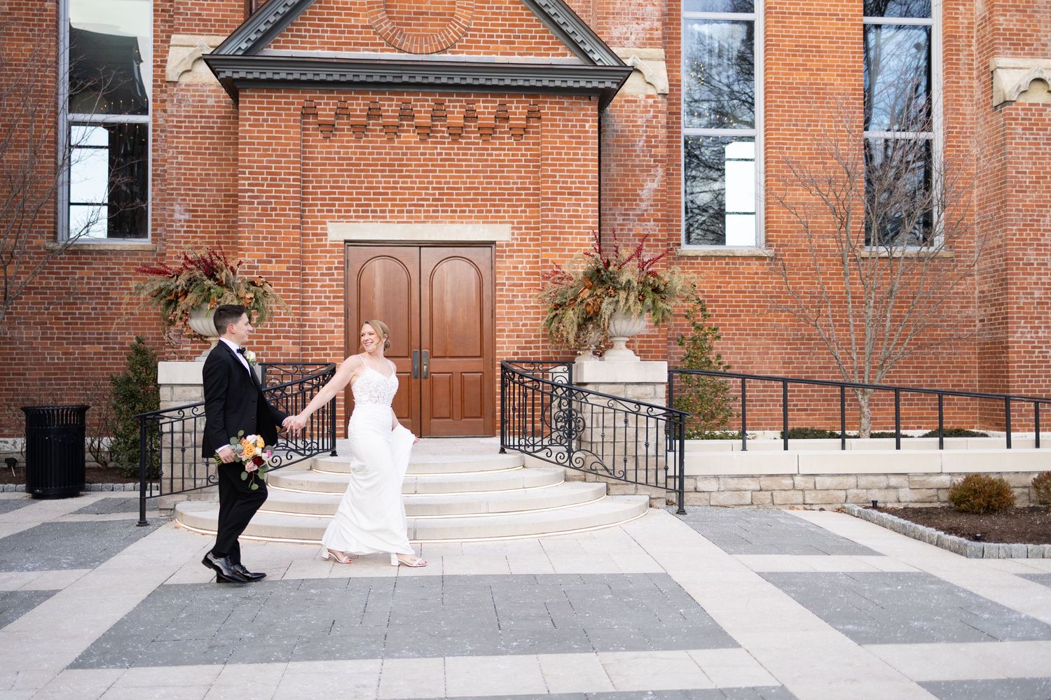 Bride and groom holding hands outside the Monastery Event Center in Cincinnati on their wedding day.