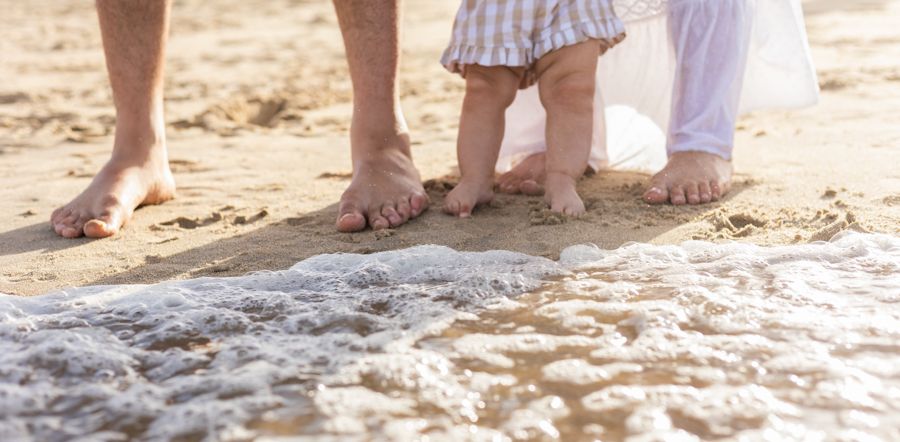 beach family session with toes in the sand on the shore line