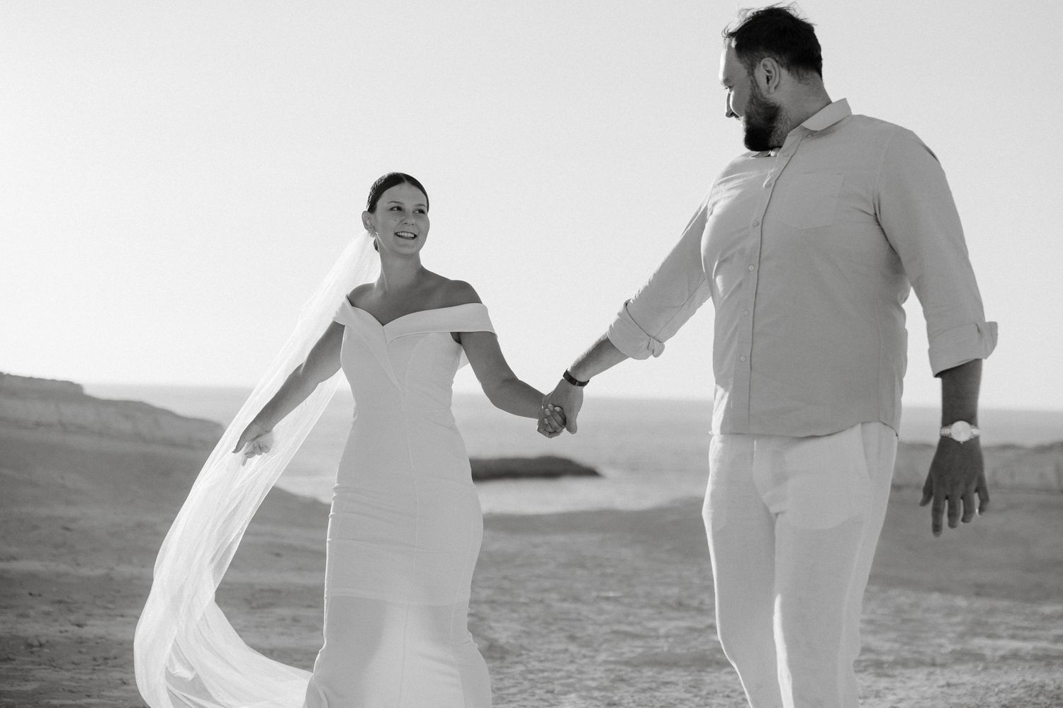 Bride and groom dance and move gracefully together of artistic black and white photographs taken on a destination Cyprus wedding.