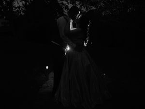 A romantic couple dancing together in the dark with a soft light illuminating their silhouettes.