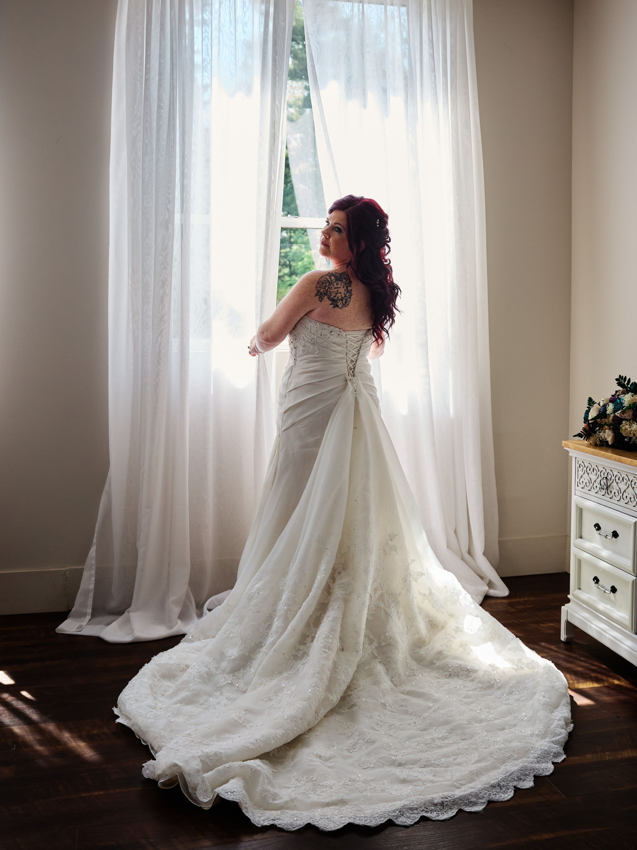 Wedding dress sequence showing elegant lace train and flowing white gown in a sunlit dressing room.