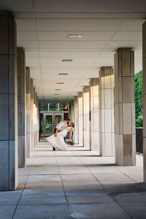 An elegant architectural colonnade with natural light streaming through creates a dramatic corridor.