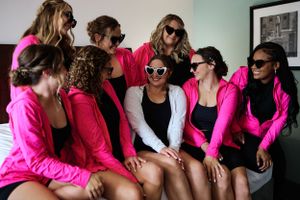 Bridesmaids wearing bright pink robes gather together for a pre-wedding photo session.