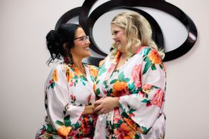 Two people in colorful floral robes share a joyful moment together.