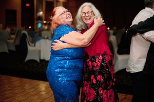 Dance floor moment at wedding reception with colorful evening lighting.