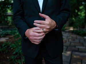 A series of cropped photos showing hands adjusting a black suit jacket and tie in formal attire.