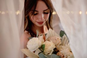 A dreamy portrait showing a bouquet of white roses and florals illuminated by soft bokeh lights in the background.