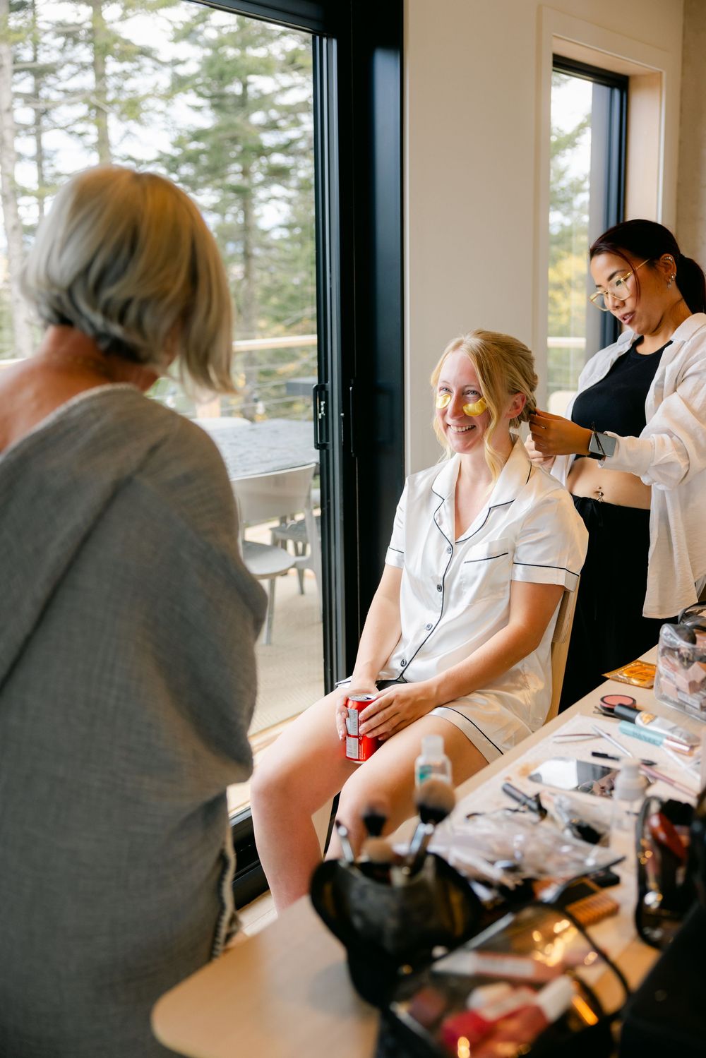 Preparations taking place in a bright room with large windows as styling services are being provided.