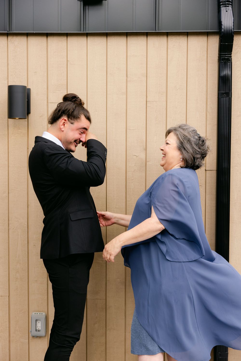 Three sequential photos show two people in business attire and scrubs demonstrating self-defense moves against a wall.