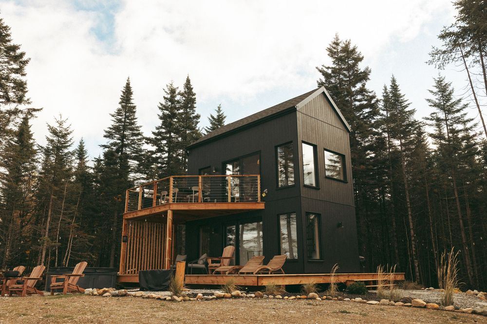 Panoramic collage of modern wooden cabin rentals nestled among tall pine trees in a forest setting.