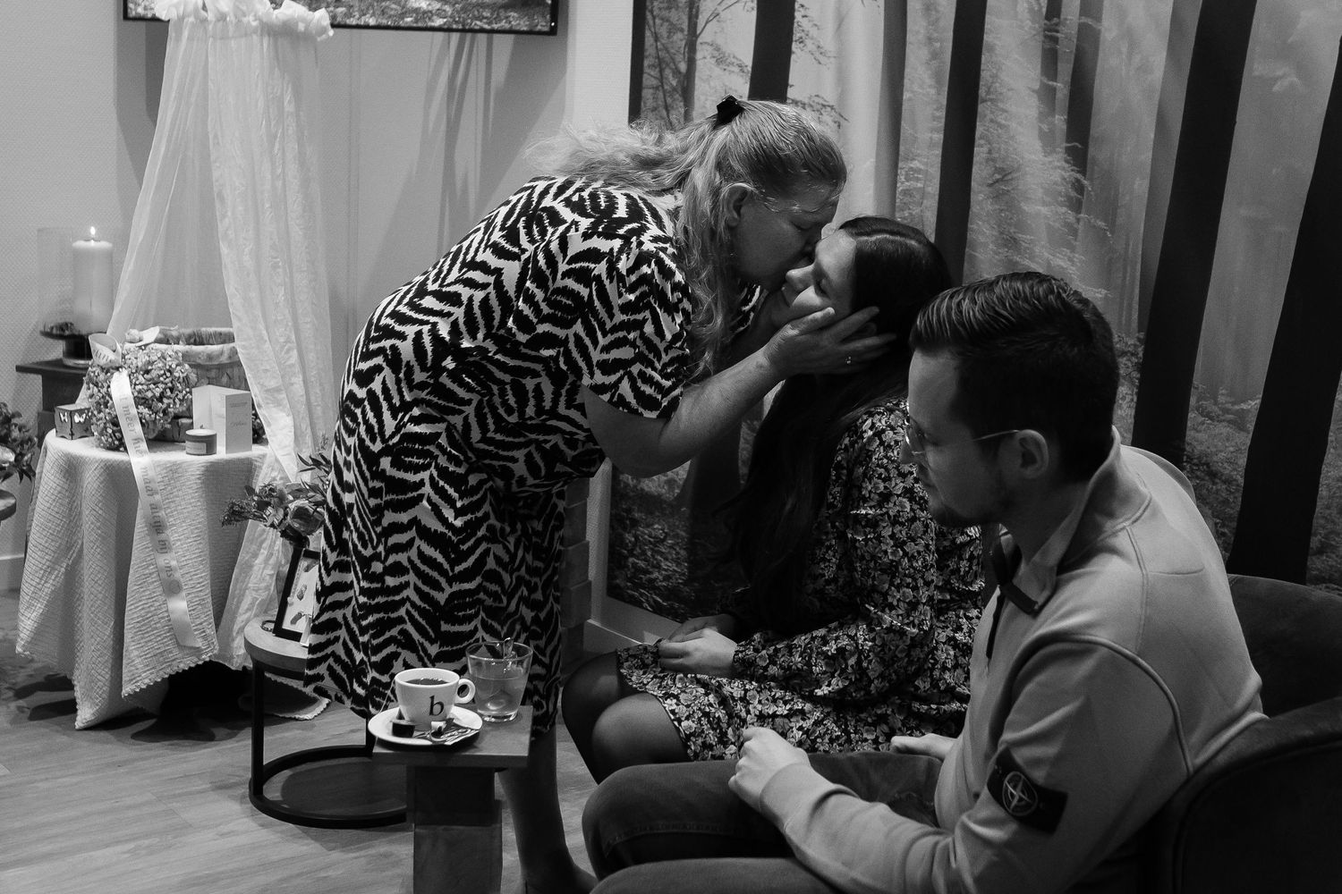 An intimate gathering moment captured in black and white with decorative elements visible.