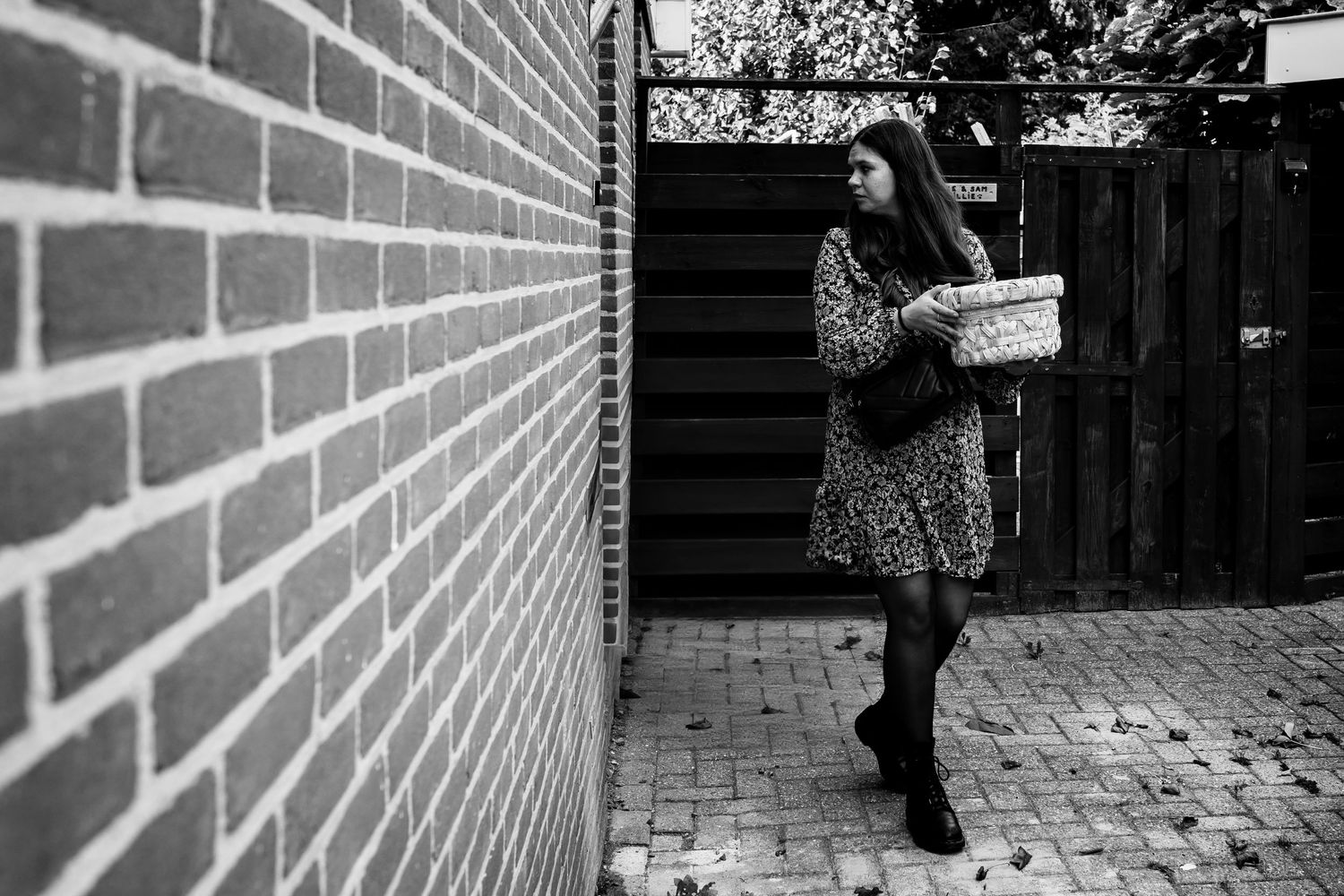 People walking along brick wall in black and white composition.