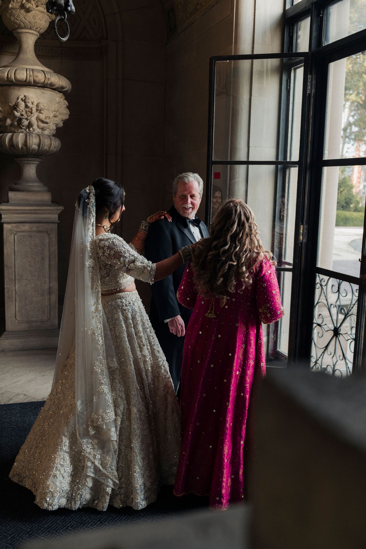 First look between a bride and her parents at Cuneo Mansion entrance.