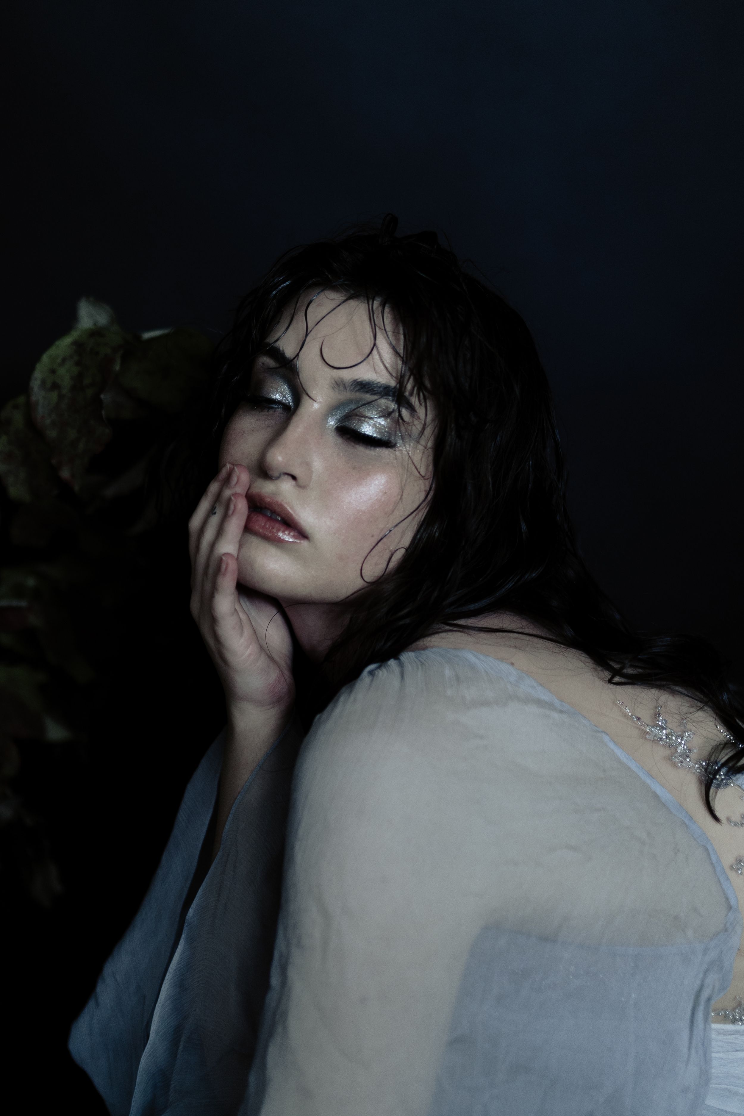 Dark and moody artistic portrait series showing dramatic shadows and expressions against a black background.