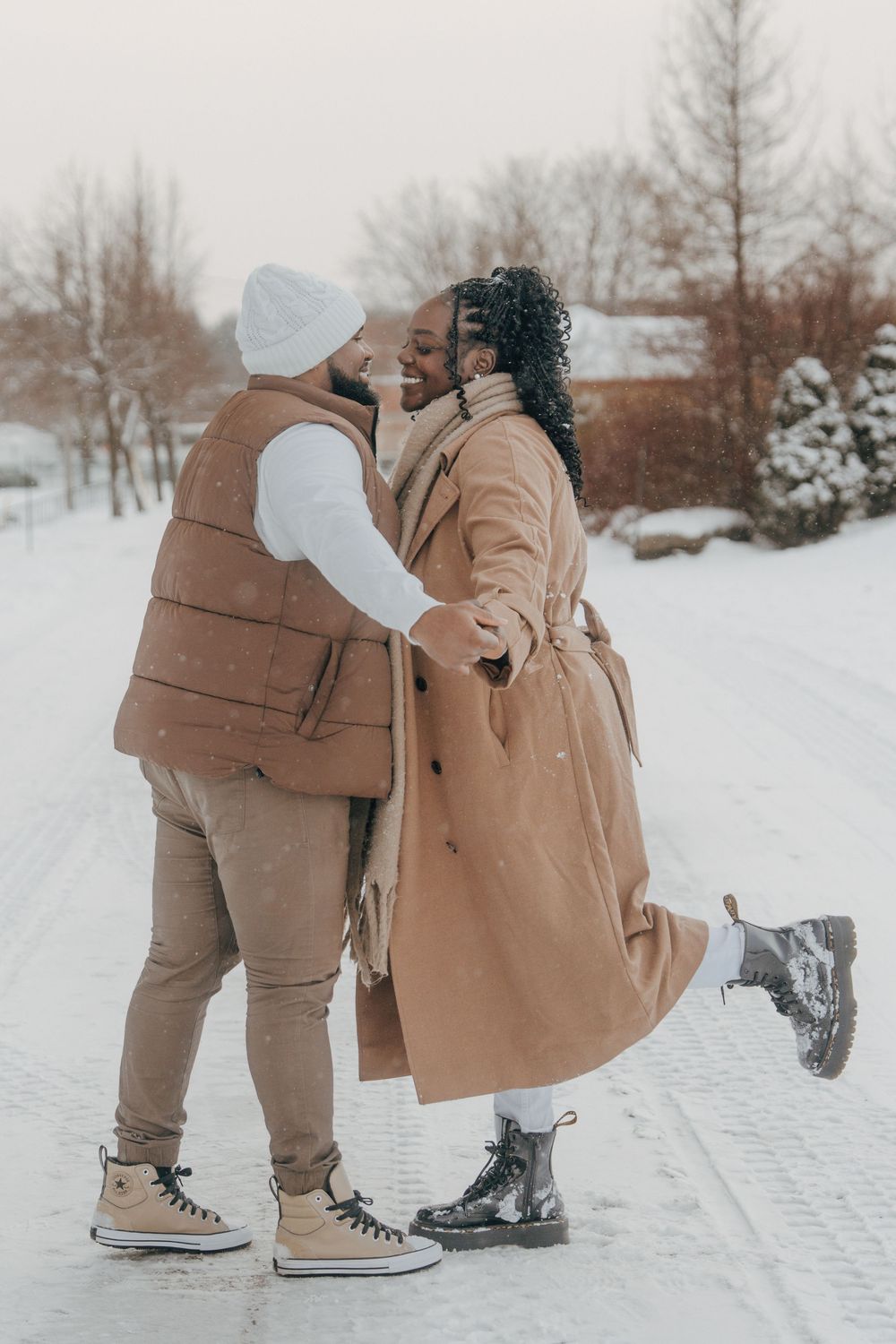 A couple in winter attire sharing romantic moments in the snow, shown in a series of four connected photos.