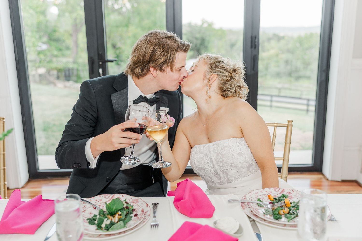 Wedding reception table setting with pink accents and formal place settings.