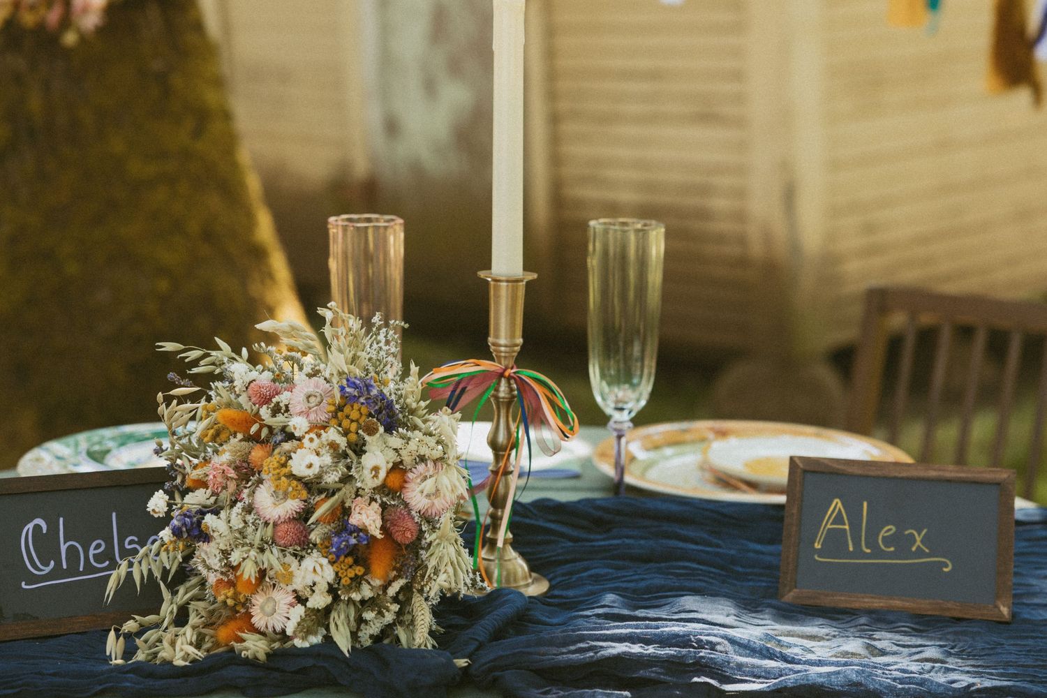 Wedding table setting with champagne flutes, candlestick and delicate floral arrangement.