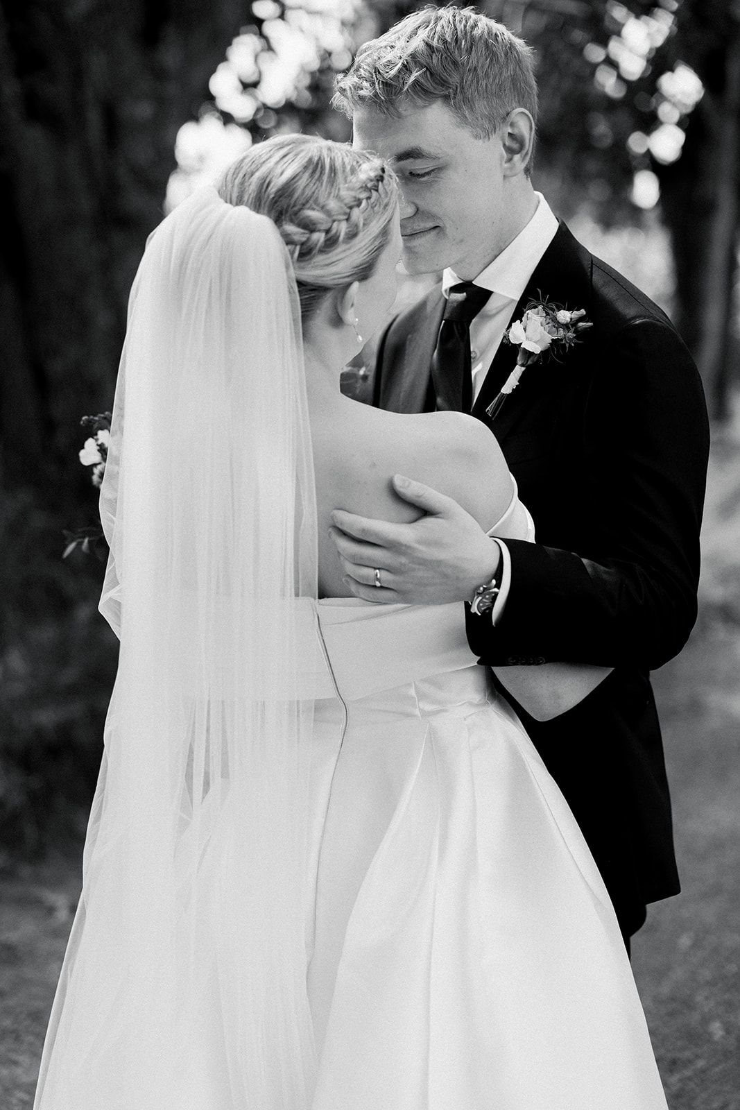 Black and white wedding photos capture intimate moments between newlyweds sharing romantic kisses outdoors.