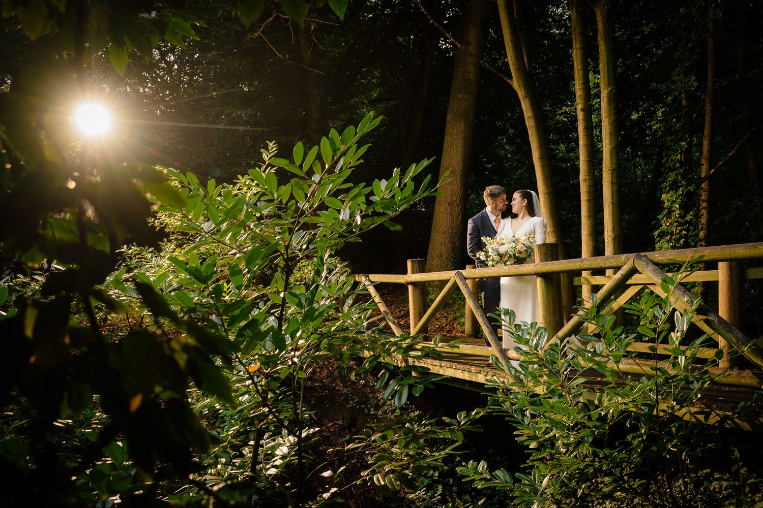 Evening garden wedding scene with dramatic lighting and natural greenery. Ellingham Hall